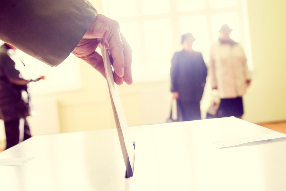 hand dropping ballot into ballot box
