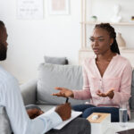 Desperate woman talking to professional psychologist at therapy session in his office
